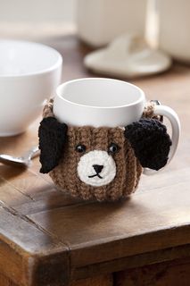 a coffee mug with a dog's head on it sitting on a wooden table