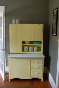 an old fashioned yellow kitchen cabinet with white counter tops