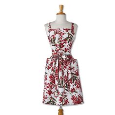 a dress on a mannequin with red berries and leaves in the front, white background