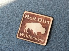 a red dirt wilderness sign is shown on a blue surface