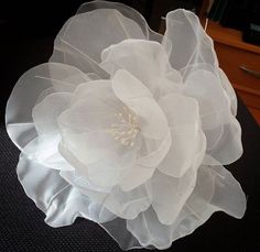 a large white flower on top of a black table