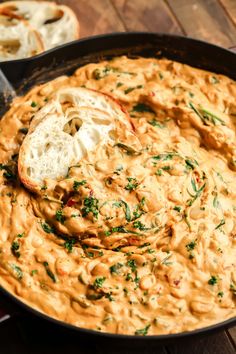 a skillet filled with hummus and garlic bread