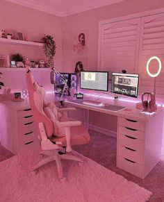 a pink room with two computer desks and a chair in front of the window