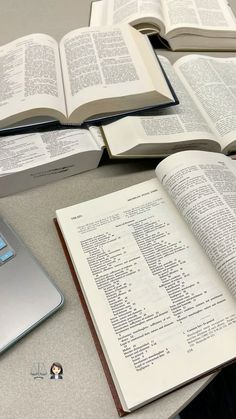 an open book sitting on top of a table next to a laptop computer and mouse