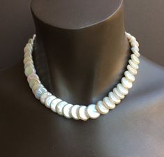 These coin pearls have been drilled in an unusual fashion so that they overlap and curve naturally around your neck. They have not been bleached, so they are a soft cream color and are particularly lustrous. You could wear these for the wedding and then keep wearing them! Looks great with jeans or in the office, or for the opera, and simple enough for everyday wear since it is really a neutral color. They are strung on Soft-flex cable and finished with my signature beads and clasp in sterling si Handmade Elegant Shell Necklace, Elegant Handmade Round Shell Necklace, Handmade Elegant Round Shell Necklace, Handmade Mother Of Pearl Round Necklace, Handmade Mother Of Pearl Necklace, Round Mother Of Pearl Necklace With Pearl Drop, Wedding Mother Of Pearl Necklace, Pearl Pendant Necklace In Mother Of Pearl, Round Mother Of Pearl Drop Necklace