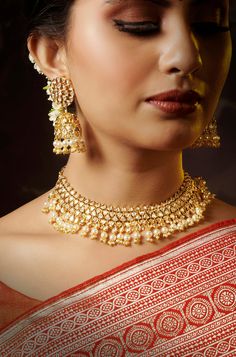 This captivating kundan set exudes both beauty and grandeur, featuring an intricate design that combines elegance with dramatic flair. Its striking 22K gold-plated mixed metal base is embellished with stunning kundan stones, creating a unique and eye-catching look. The set is complete with matching jhumkis that add a touch of opulence and sophistication. Ideal for special occasions, this set is sure to make a memorable statement, effortlessly blending tradition with contemporary glamour. Finish: Gold Tilla Sets For Transitional Season, Transitional Gold Sets With Meenakari Detail, Transitional Gold Sets With Meenakari, Transitional Gold Meenakari Sets, Elegant Heavy Bridal Necklace For Eid, Gold Kundan Sets For Reception, 22k Gold Chandbali Kundan Necklace, Gold Jewelry For Eid Reception, Elegant Gold Kundan Chandbalis