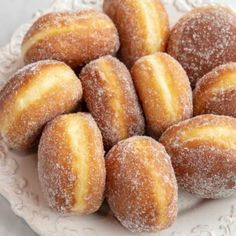 powdered sugar covered donuts on a white plate