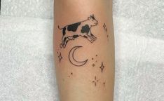 a cow is standing on the moon and stars tattoo