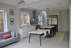 a kitchen and living room are separated by an open floor plan, while the dining area is adjacent to the kitchen