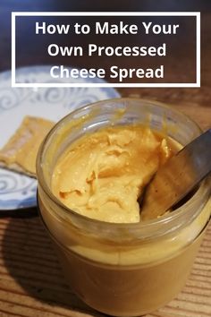 a glass jar filled with cheese spread on top of a wooden table