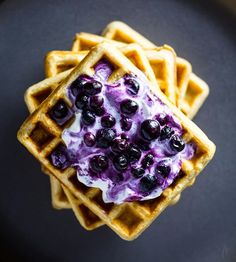 waffles with blueberries and whipped cream on top are arranged in the shape of a square