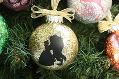 an ornament on a christmas tree decorated with glitter and silhouettes is shown