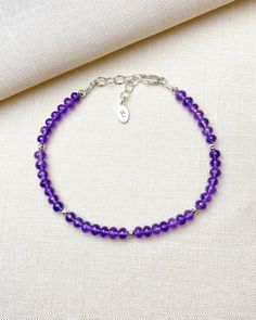 Treat her royally, with a gemstone bracelet the color of royalty. This sublime beaded bracelet features a strand of micro-faceted amethyst stones in the most rich shade of purple. Small sterling silver beads interspersed along the strand add extra brilliance to this refined design. A secure lobster clasp and extender chain allow a comfortable fit for most wrists, so you can be confident when gifting that it will fit. Amethyst is the birthstone for February Amethyst is also traditionally given for the sixth wedding anniversary Amethyst is a purple shade of quartz Bracelet length: 7.25 inches plus 1-inch extender Materials: 3.5-4 mm amethyst beads, .925 sterling silver components, multi-strand stainless steel beading wire Free USA shipping and returns. Elegant Sterling Silver Beaded Bracelets With Gemstone, Spiritual Polished Beads Bracelets, Elegant Amethyst Gemstone Crystal Bracelet, Adjustable Purple Beaded Bracelet With Silver Beads, Adjustable Amethyst Beads For Jewelry Making, Elegant Purple Beaded Bracelets With Silver Beads, Elegant Sterling Silver Healing Crystal Bracelet, Adjustable Purple Beaded Bracelet With Faceted Beads, Sterling Silver Rondelle Gemstone Beaded Bracelets