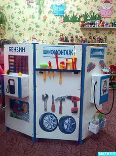 there is a toy machine with tools on it in the living room and children are sitting at the table