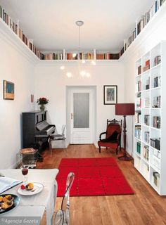 a living room filled with furniture and bookshelves full of bookcases next to a dining table