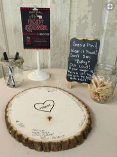 there is a sign that says baby shower on the table next to a tree stump