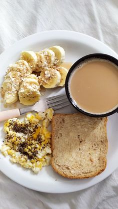 a white plate topped with toast, eggs and bananas