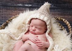 a newborn baby is sleeping in a basket wearing a crocheted hat and blanket