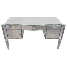 a mirrored desk with three drawers on it