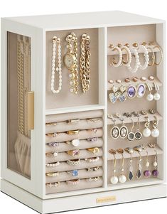 a white jewelry box filled with lots of different types of necklaces and earrings on display