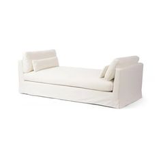 a white chaise lounger with pillows on it's back and arms, viewed from the front