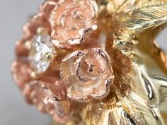 This pretty ring was crafted by the mid-century, with 14 karat gold in leaves and roses of rose gold forming a sweet bouquet center. This pretty piece has a stunning round brilliant diamond, a sparkling contrast to the softly textured petals of the flower.Metal: 14K Yellow and Rose GoldGem: Diamond .11 Carats, SI1 in Clarity, G in ColorGem Measurements: 3.0 mm, RoundRing Size: 4.75 Heirloom Rose Gold Diamond Flower Ring, Vintage 14k Rose Gold Flower Ring, Vintage Rose Gold 14k Gold Flower Ring, Heirloom Rose Gold Flower Ring, Vintage Rose Flower Ring For Wedding, Vintage Rose Gold Flower Ring For Formal Occasions, Vintage Rose Gold Flower Ring For Formal Events, Diamond Bouquet, Bouquet Ring