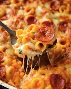 a close up of a person holding a spoon with some food on it in a casserole dish