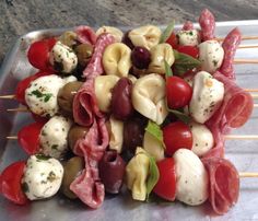 several skewers filled with meat and veggies on top of a metal tray