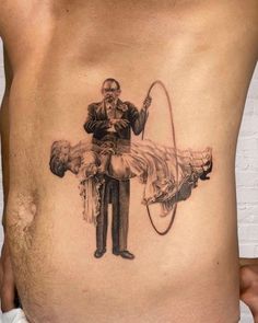 a man with a tattoo on his stomach holding a fishing rod and a fish hook