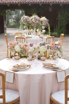 the table is set with flowers and gold plates