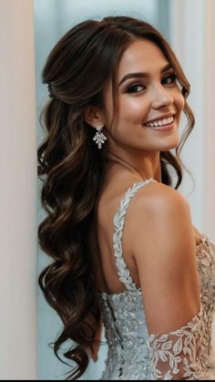 a beautiful young woman with long brown hair wearing a white dress and smiling at the camera