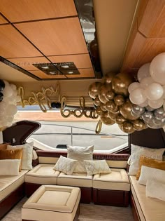 a living room filled with lots of furniture and balloons hanging from the ceiling above it