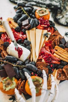 a platter filled with cheese, fruit and crackers on top of each other