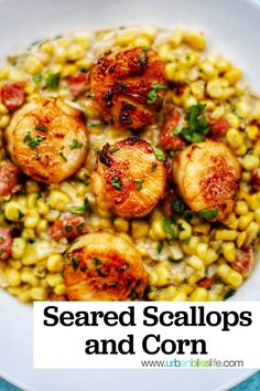 a white bowl filled with corn and scallops on top of a blue table