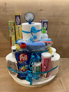 a diaper cake that is sitting on a plate with blue ribbon and other items