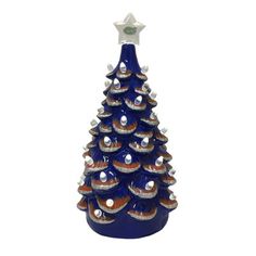 a blue ceramic christmas tree ornament on a white background