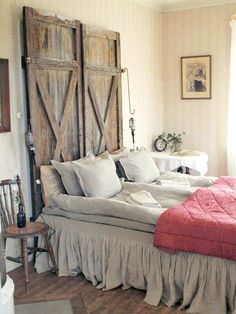 a bed sitting in a bedroom next to a wooden headboard with two doors on it