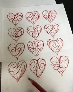 someone is drawing hearts with red ink on paper