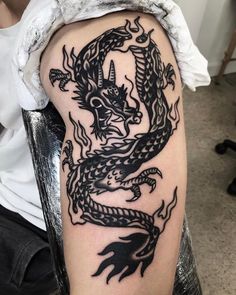 a black and white dragon tattoo on the arm