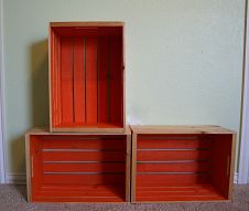 two wooden boxes sitting next to each other on the floor in front of a wall