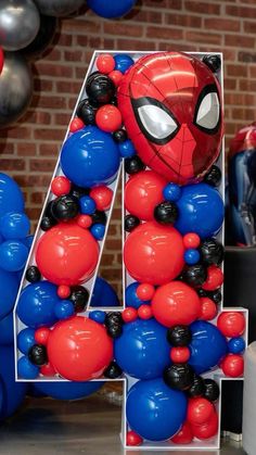 the number four is made up of balloons and spiderman balloons in red, white, and blue