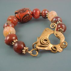 "Agate Bracelet has a mix of Agate with Hand Painted Ceramic Beads, Large Wood Bead, and Hand Made Brass Clasp  The clasp is a beautiful work of art. Bracelet is 7.5\" long. Allow 1/2\" because of the chunky stone on this piece." Ceramic Beads Bracelet, Art Bracelet, Wood Bead Bracelet, Artisan Bracelets, Unusual Jewelry, Hand Painted Ceramic, Agate Bracelet, Ceramic Beads, Etsy Jewelry