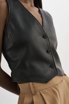 Faites connaître votre expertise en mode avec le gilet en cuir Kallie - une pièce contemporaine et intemporelle qui respire l'élégance sans effort. Avec son encolure en V élégante et son ourlet asymétrique, ce gilet chic ajoute une touche de modernité à n'importe quelle tenue. Fabriqué à partir de cuir souple, le gilet est un témoignage de sa qualité exceptionnelle et de sa texture supérieure. Portez-le avec un short et une paire de talons à lanières pour un look tendance qui ne manquera pas d Leather Vest Top, Leather Gilet, Women Leather Vest, Leather Blouse, Leather Waistcoat, Leather Outerwear, Short Vest, Future Clothes, Wardrobe Planning