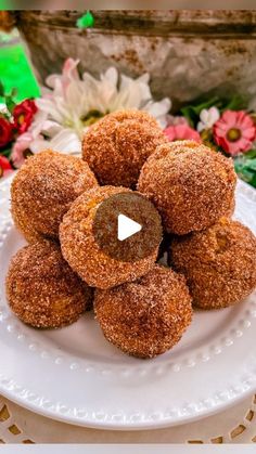 a white plate topped with donuts covered in powdered sugar on top of a table