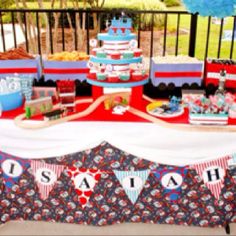 a table topped with cake and desserts on top of a red white and blue blanket