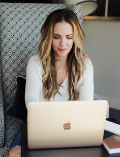 a woman sitting in front of a laptop computer