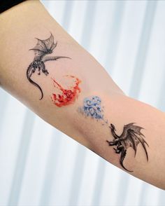 a woman's arm with tattoos on it and two birds flying in the sky