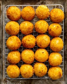 some food that is sitting on a wire rack in front of a metal tray with muffins