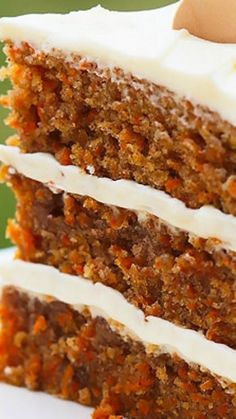 a slice of carrot cake with white frosting and an egg in the middle on a plate