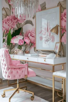 a desk with a pink chair and flowers on the wall